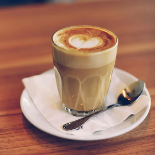 A glass of skinny latte with steamed milk on top