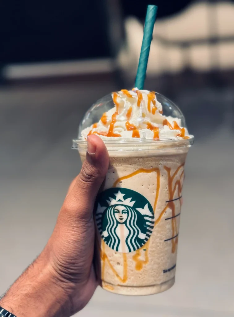 A cup of Starbucks coffee with whipped cream on top